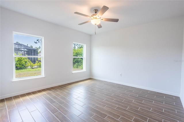 empty room with dark hardwood / wood-style floors and ceiling fan