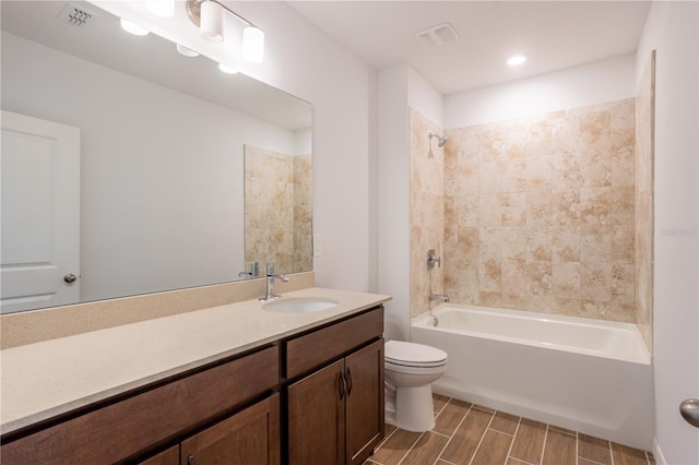 full bathroom with vanity, tiled shower / bath combo, and toilet