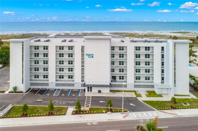 view of building exterior featuring a beach view and a water view