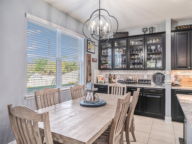 tiled dining space featuring an inviting chandelier