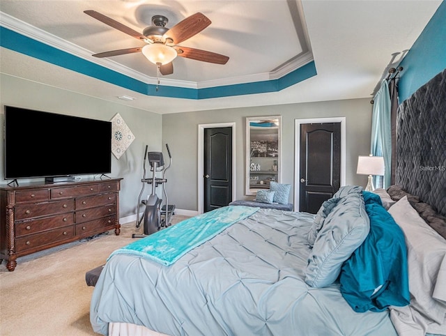 carpeted bedroom featuring a raised ceiling, ceiling fan, and ornamental molding