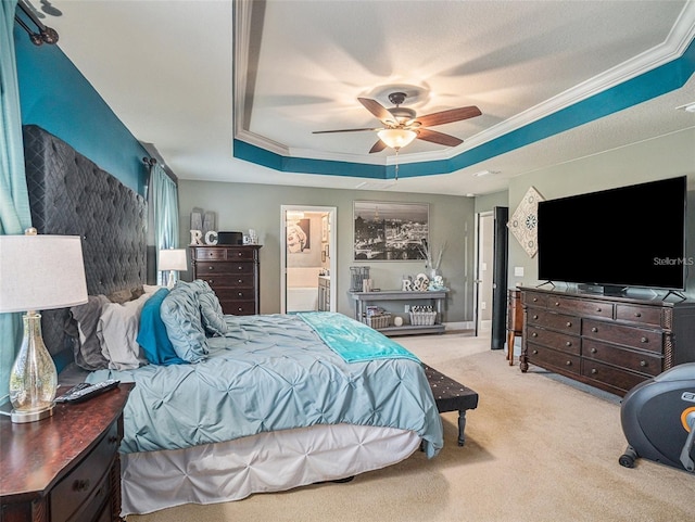 carpeted bedroom featuring ceiling fan, a raised ceiling, crown molding, and connected bathroom