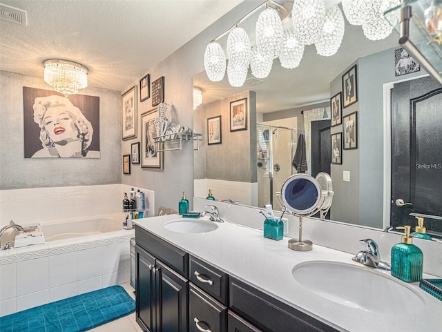 bathroom featuring an inviting chandelier, tile patterned flooring, a textured ceiling, vanity, and independent shower and bath