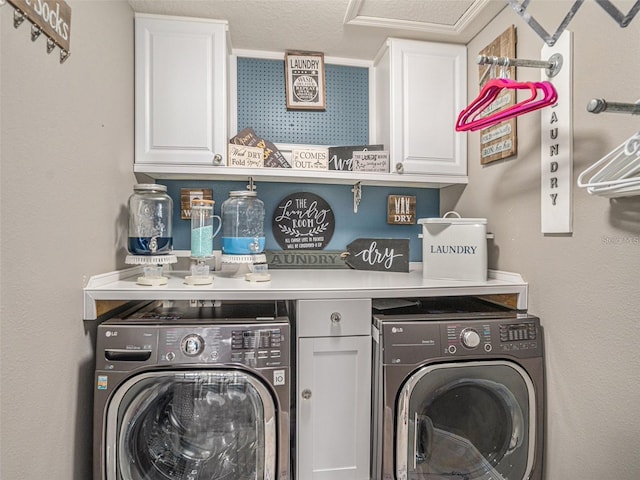 laundry area with cabinets, a textured ceiling, and washing machine and dryer