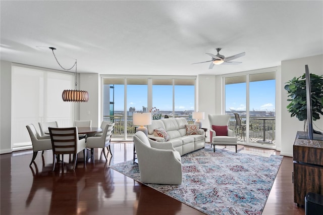 living room featuring ceiling fan, dark hardwood / wood-style floors, and a wall of windows