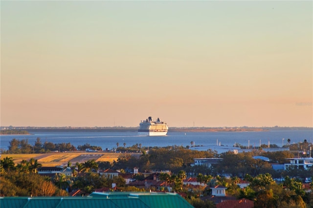 aerial view at dusk featuring a water view