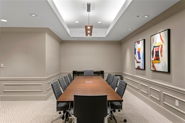 carpeted dining space with crown molding and a tray ceiling