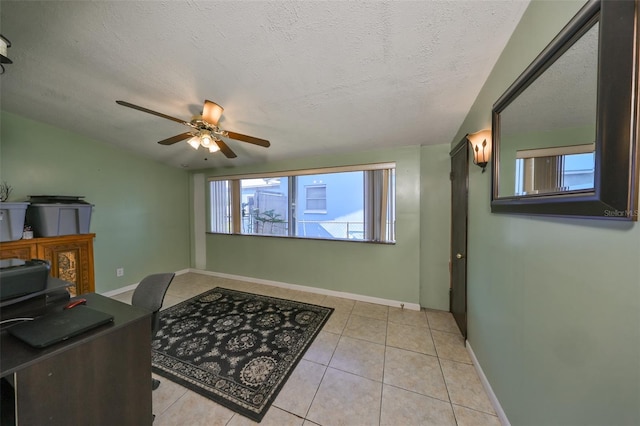 tiled home office with ceiling fan and a textured ceiling