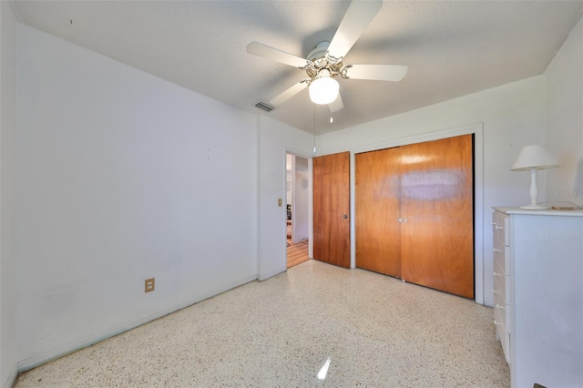 unfurnished bedroom with ceiling fan, a textured ceiling, and a closet