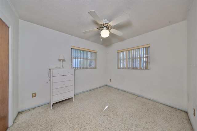 unfurnished bedroom featuring a textured ceiling and ceiling fan