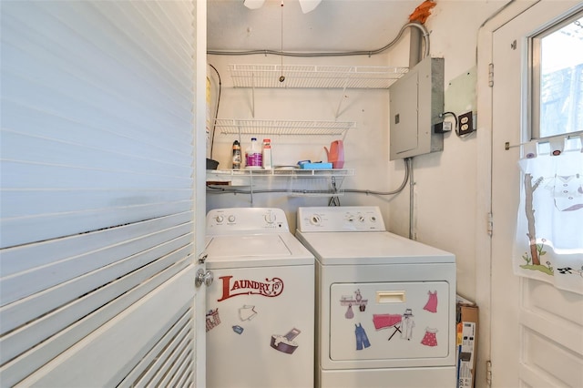 laundry room with electric panel and washer and clothes dryer