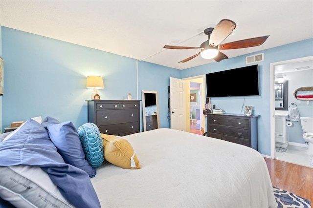 bedroom featuring ensuite bath, ceiling fan, and hardwood / wood-style floors