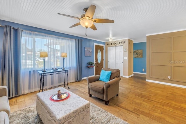 sitting room featuring light hardwood / wood-style floors, crown molding, and ceiling fan