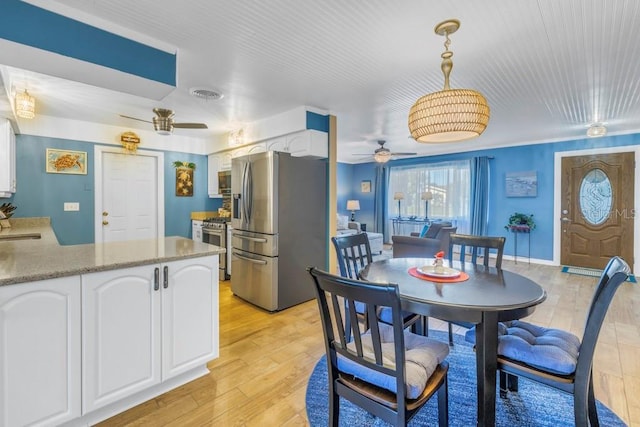 dining room featuring light wood-type flooring, ceiling fan, and sink