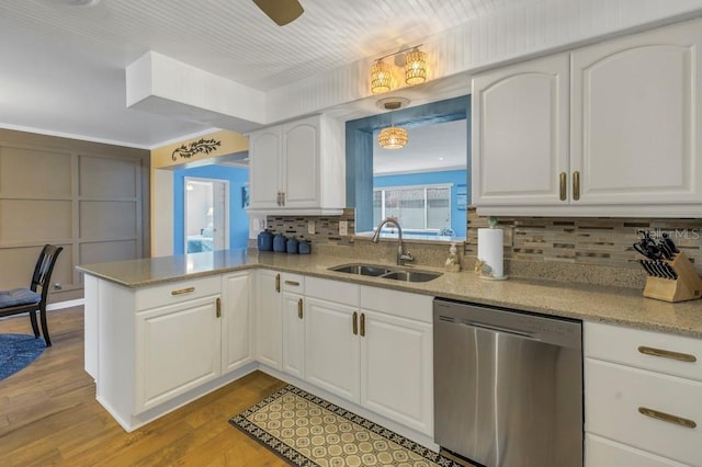 kitchen with kitchen peninsula, stainless steel dishwasher, sink, light wood-type flooring, and white cabinetry