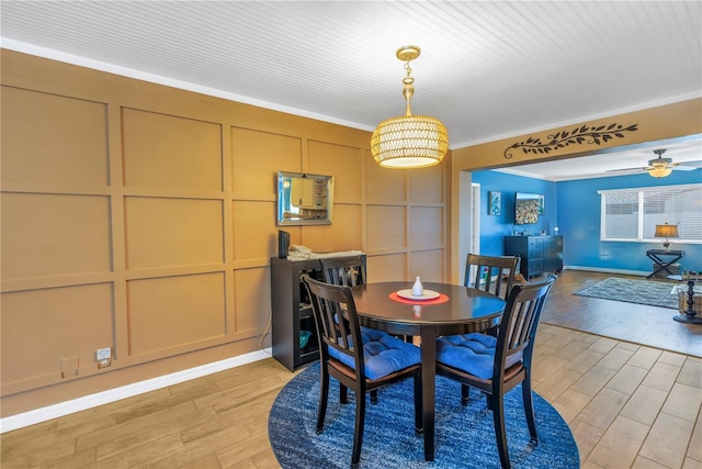 dining space with ceiling fan and ornamental molding