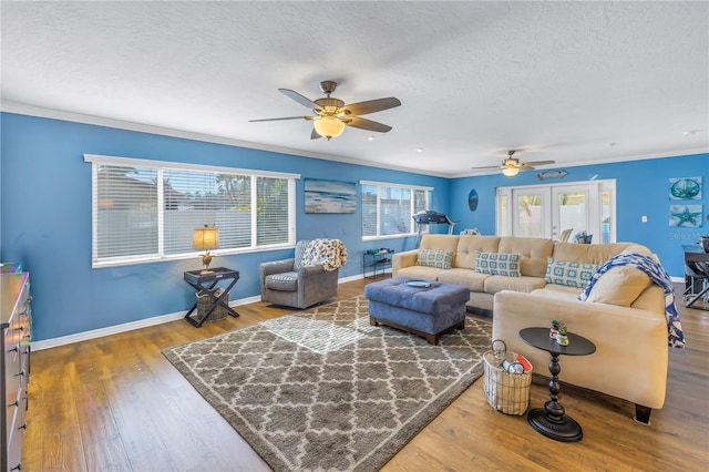 living room featuring hardwood / wood-style flooring, a textured ceiling, ceiling fan, and ornamental molding