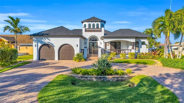 mediterranean / spanish-style home with covered porch, a garage, and a front lawn