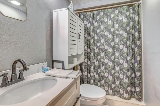 bathroom with vanity, toilet, and a textured ceiling