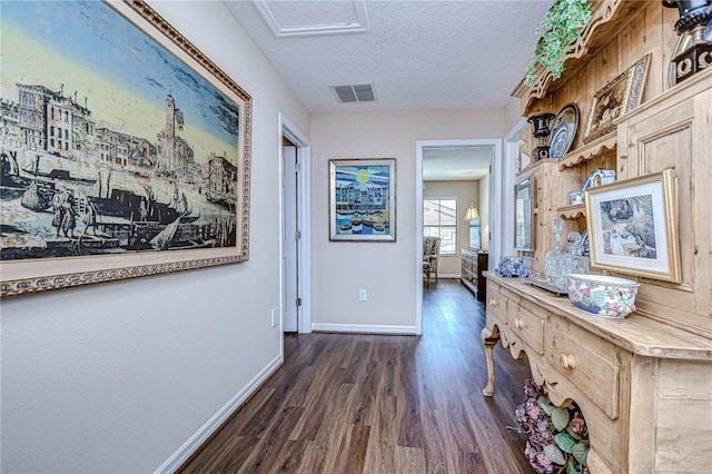 corridor featuring a textured ceiling and dark hardwood / wood-style floors