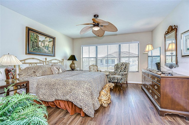 bedroom featuring ceiling fan, dark hardwood / wood-style floors, and a textured ceiling