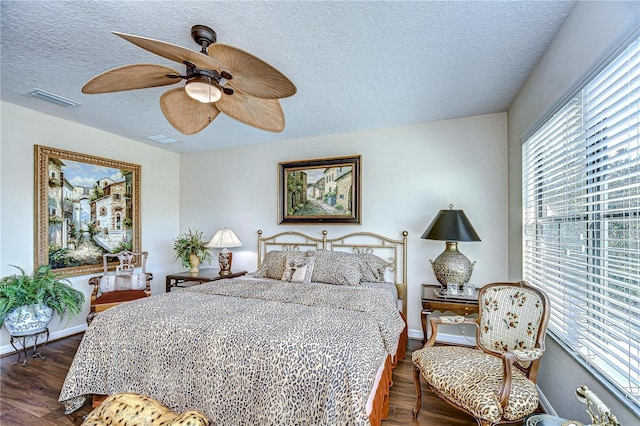 bedroom featuring a textured ceiling, ceiling fan, and dark hardwood / wood-style floors