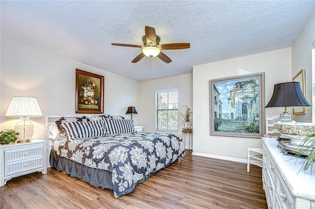 bedroom with a textured ceiling, hardwood / wood-style flooring, and ceiling fan