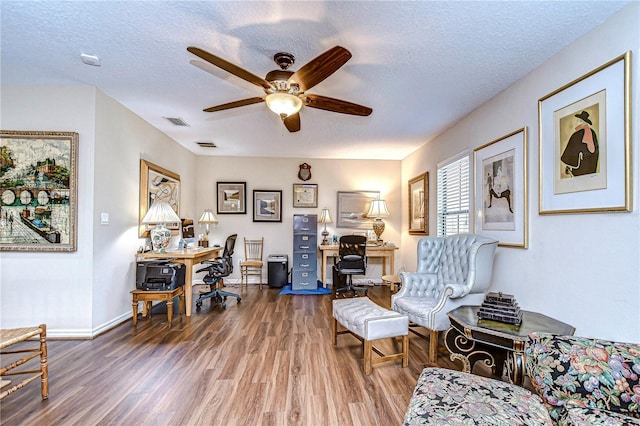 living area with dark hardwood / wood-style floors, ceiling fan, and a textured ceiling