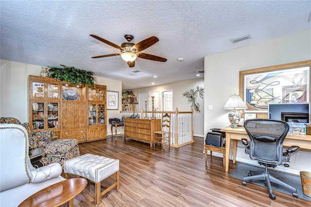 home office featuring a textured ceiling, hardwood / wood-style flooring, and ceiling fan