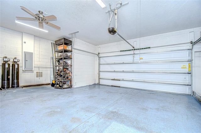 garage featuring electric panel, a garage door opener, and ceiling fan