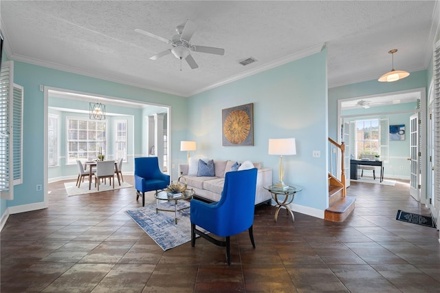 living room featuring ceiling fan with notable chandelier, a textured ceiling, and ornamental molding