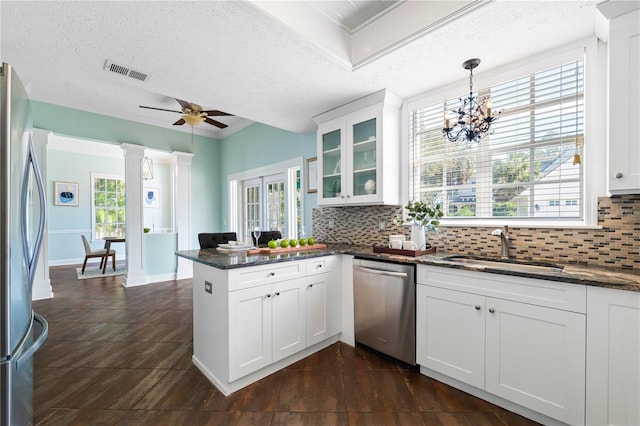 kitchen with a textured ceiling, pendant lighting, white cabinetry, and stainless steel appliances