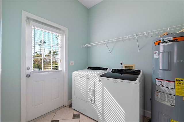 washroom featuring washer and clothes dryer, light tile patterned floors, and water heater