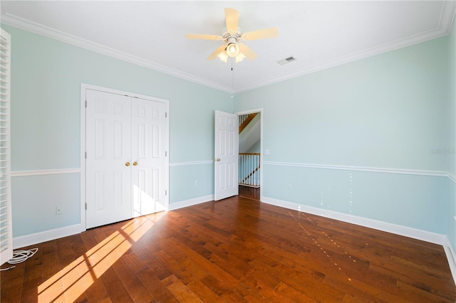 unfurnished bedroom featuring dark hardwood / wood-style flooring, ceiling fan, and crown molding