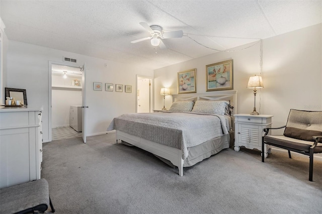 carpeted bedroom with ceiling fan and a textured ceiling