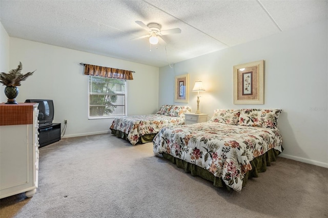 carpeted bedroom featuring ceiling fan and a textured ceiling