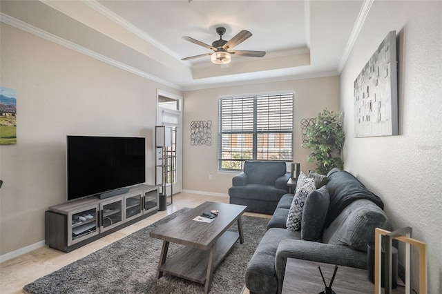 living room featuring a tray ceiling, crown molding, and ceiling fan