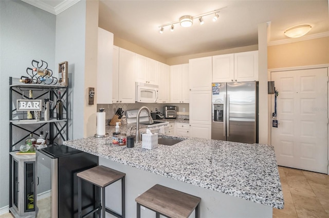 4221 W Spruce St Unit 2418, Tampa, FL 33607 - kitchen featuring white appliances, a peninsula, light stone countertops, white cabinetry, and a kitchen bar