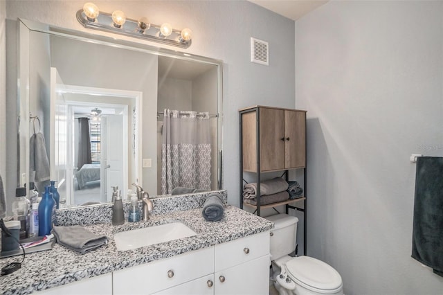 bathroom with a shower with curtain, vanity, ceiling fan, and toilet