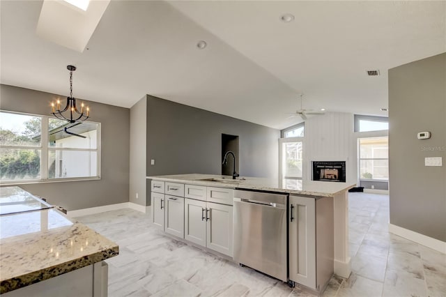 kitchen with dishwasher, white cabinets, ceiling fan with notable chandelier, sink, and vaulted ceiling