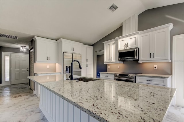 kitchen featuring light stone countertops, stainless steel appliances, sink, white cabinets, and lofted ceiling