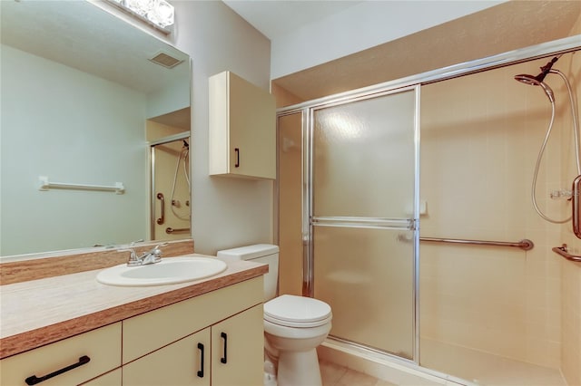 bathroom featuring tile patterned flooring, vanity, toilet, and a shower with door