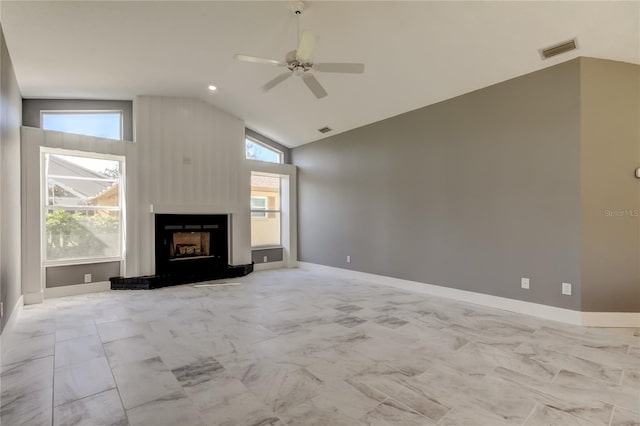 unfurnished living room featuring vaulted ceiling, a wealth of natural light, and ceiling fan