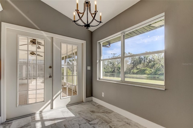 doorway to outside with lofted ceiling, french doors, and a chandelier