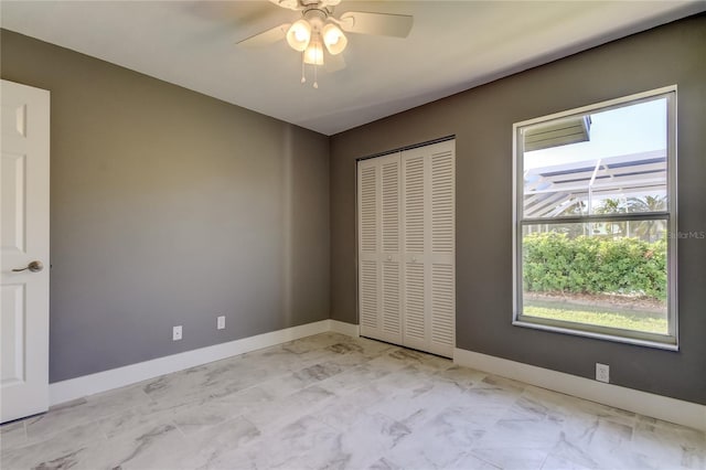 unfurnished bedroom featuring ceiling fan, a closet, and multiple windows