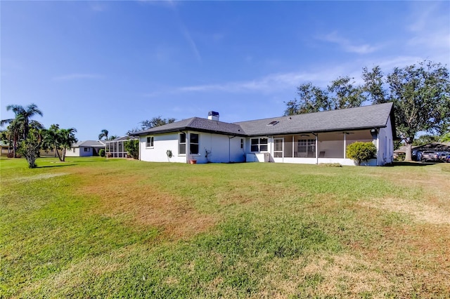 back of property featuring a lawn and a sunroom