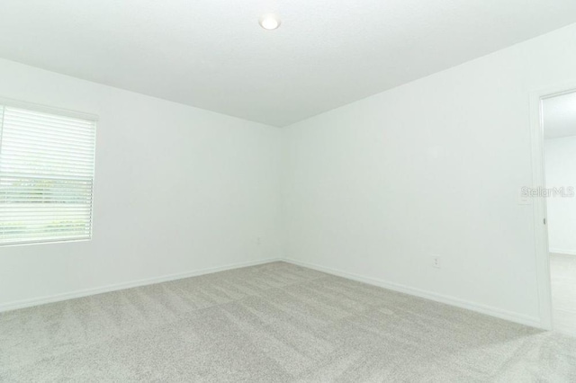 unfurnished room featuring light carpet