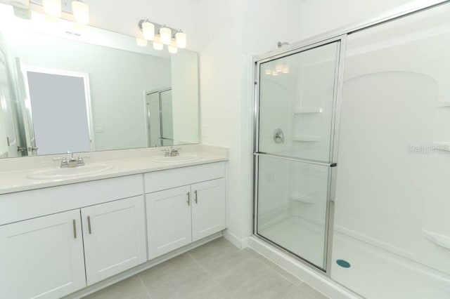 bathroom featuring tile patterned flooring, vanity, and an enclosed shower