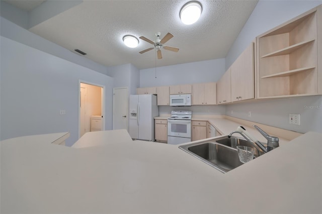 kitchen featuring a textured ceiling, light brown cabinets, white appliances, and sink