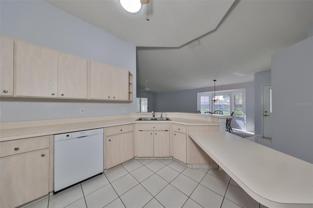 kitchen featuring dishwasher, sink, kitchen peninsula, decorative light fixtures, and light brown cabinetry